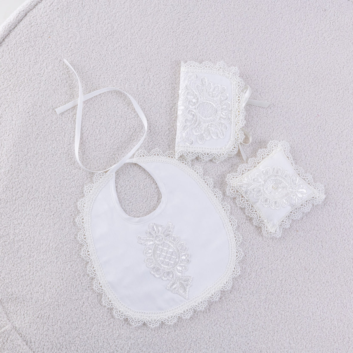 White baby bib , booties sand  First Curl Baptism Keepsake Box et on a light gray background