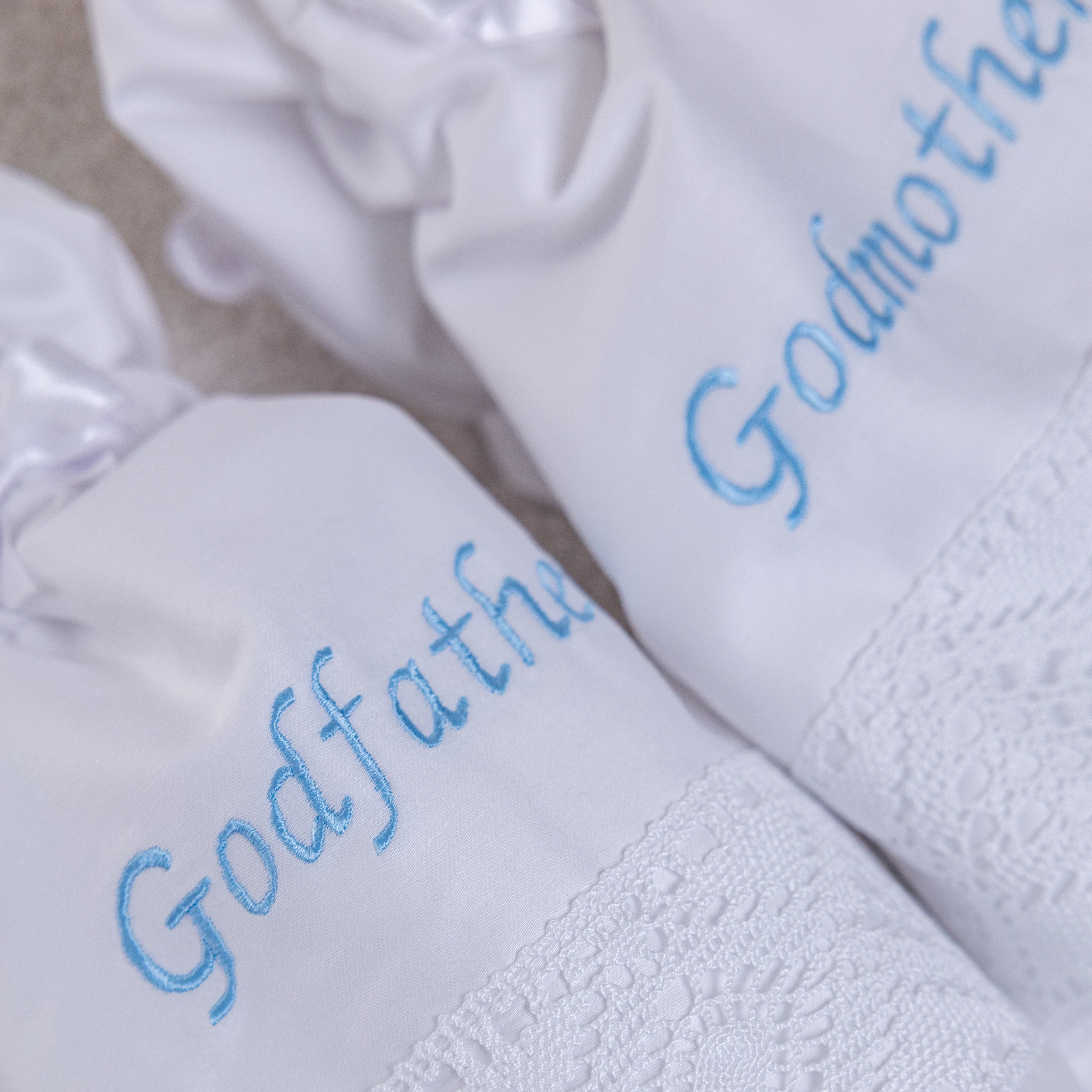 White towels with 'Godfather' embroidery on a neutral background