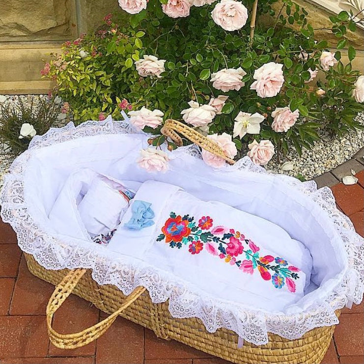 Baby crib with Newborn Sleep Sack for Summer with flowers in a garden setting