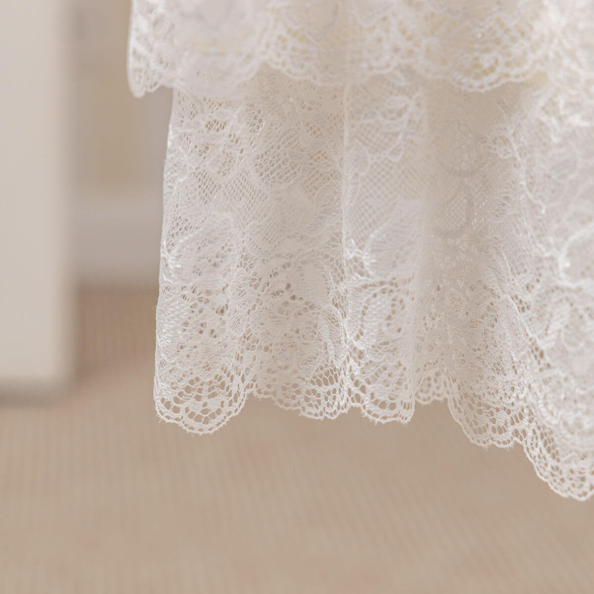 Close-up of white lace fabric on a neutral background