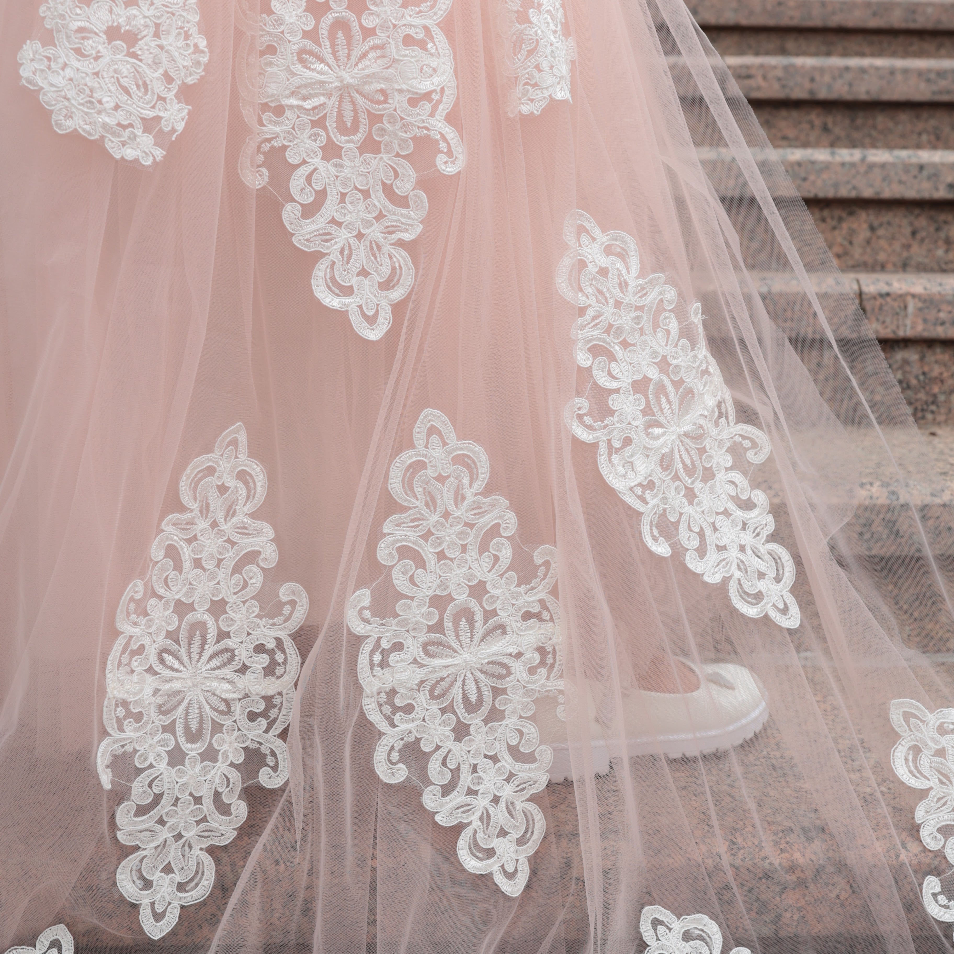 Bridal gown with white lace details on a staircase