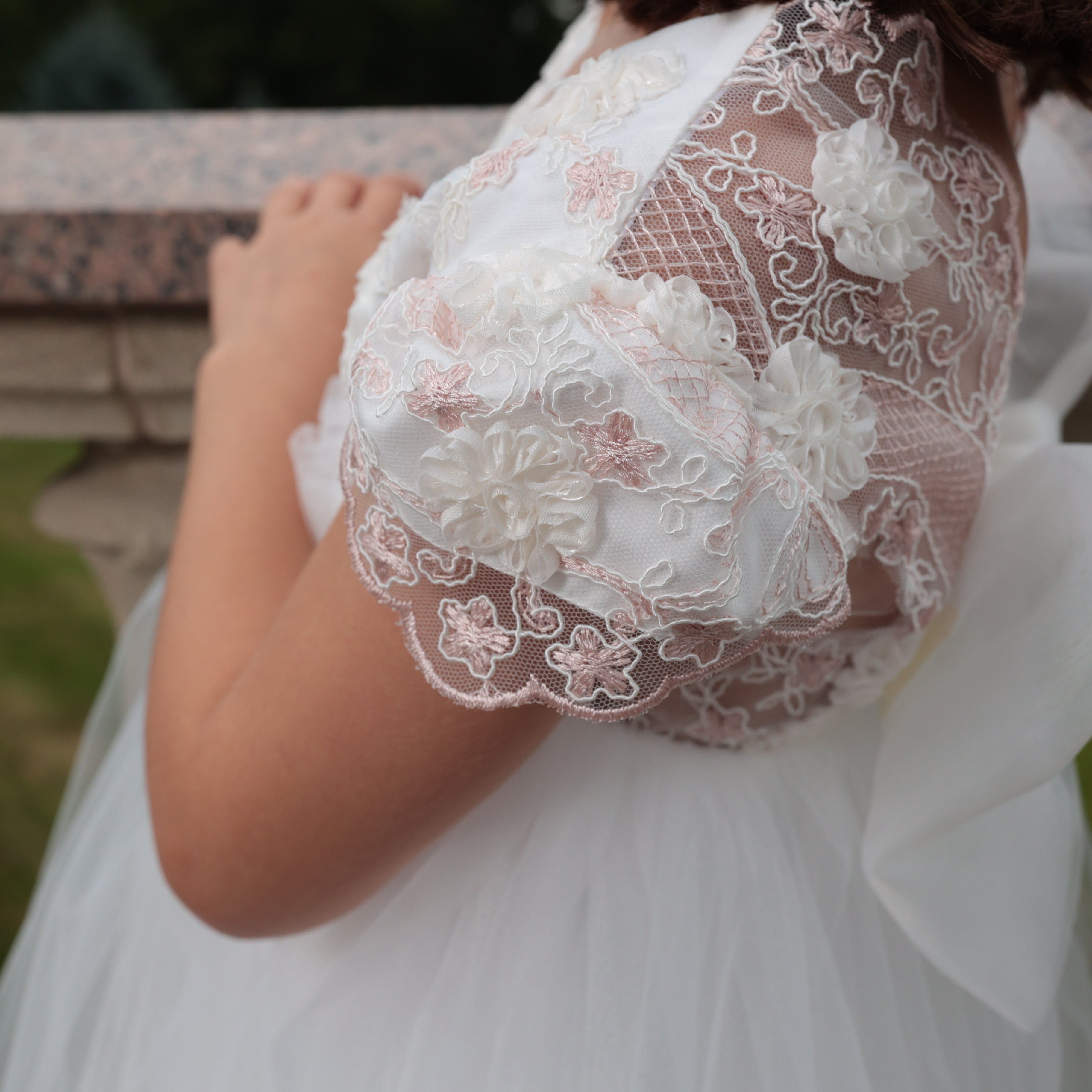 Close-up of a white lace garment with floral details on a blurred background