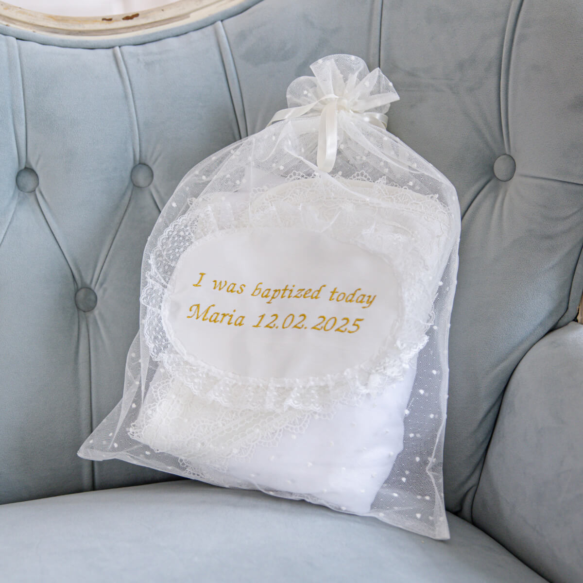 Mesh Bag with embroidered text on a gray cushioned chair.