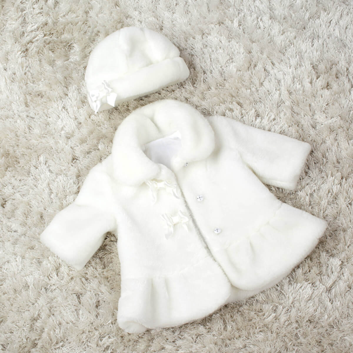 Baby Keepsake Fur Coat with Hat on a beige carpet