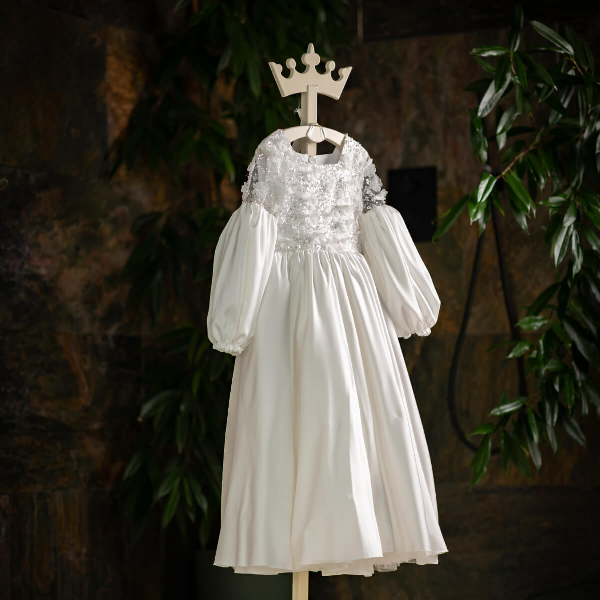 White Silk First Communion Dress with puffed sleeves on a mannequin against a dark background