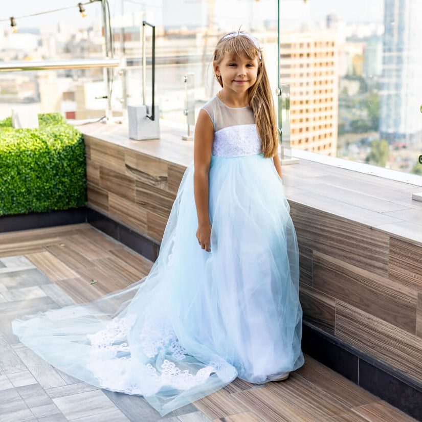 Young girl in a white dress standing on a rooftop with cityscape view