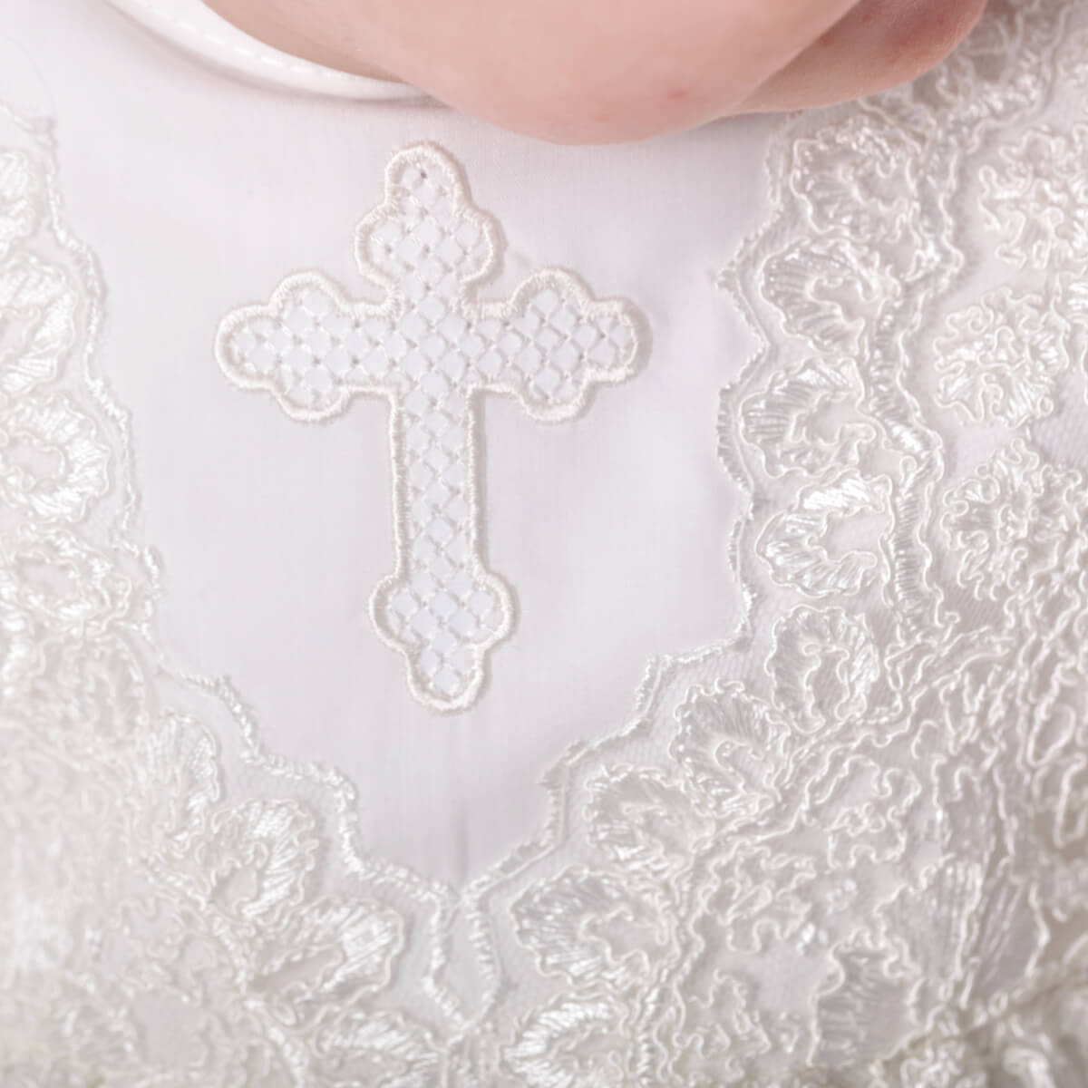 Close-up of a white embroidered cross on a Christening Gown for Girls