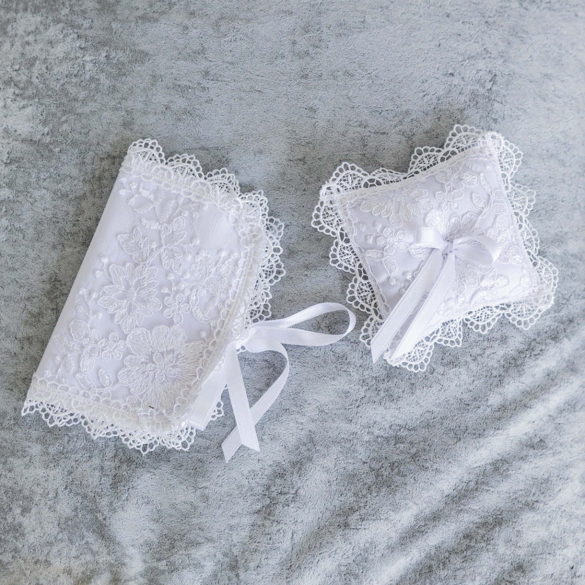 Baptism Cross Pillow with ribbons on a gray surface