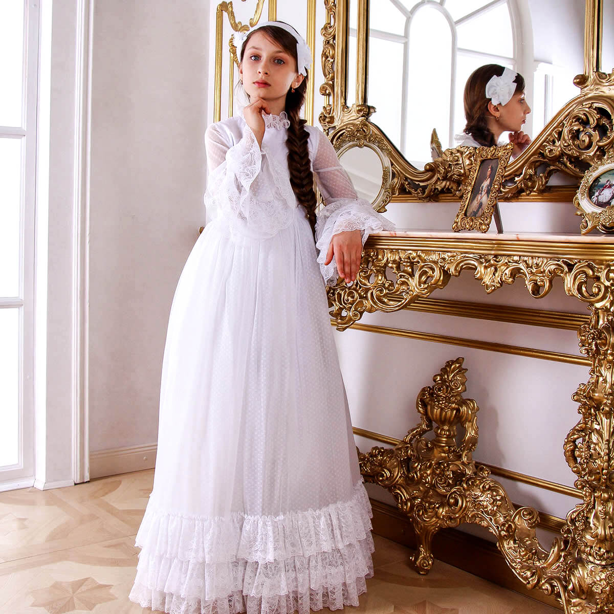 Woman in Boho Chic Communion Dress standing in front of an ornate gold mirror.