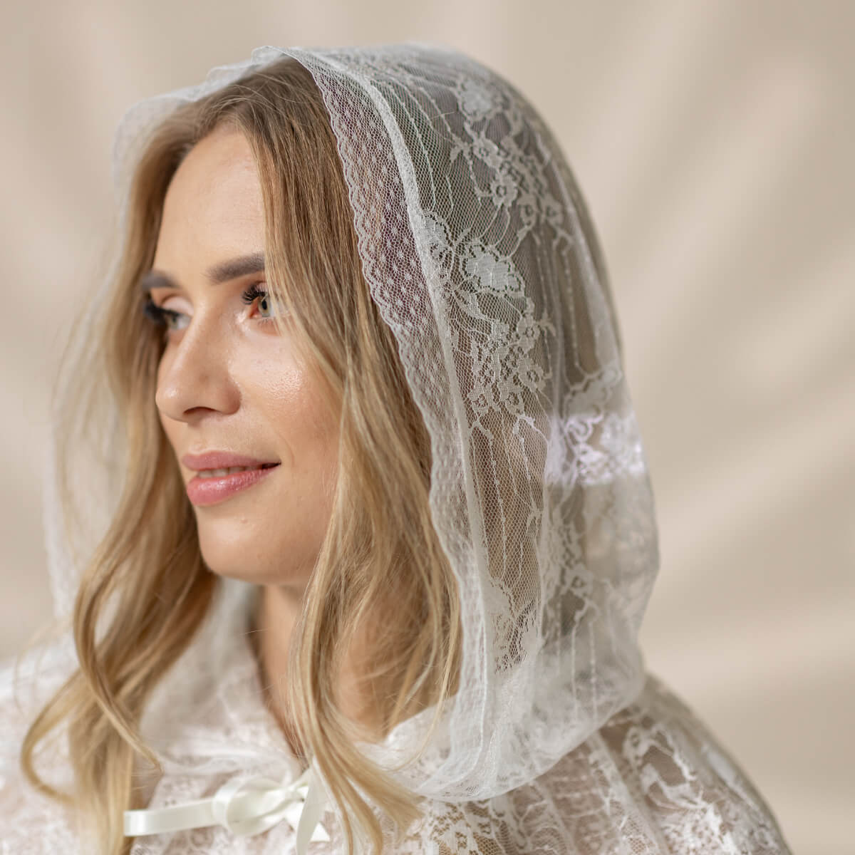 Woman wearing a Lace Hooded Veil against a neutral background