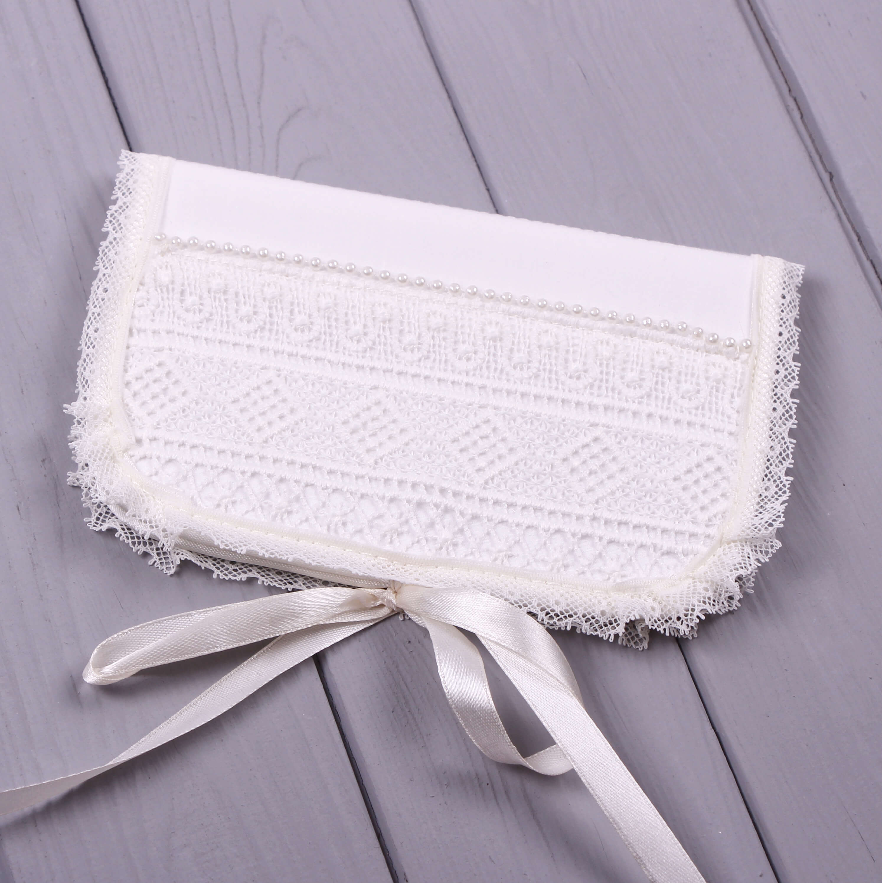 Lace Baptism Keepsake Box for First Curl with a ribbon on a gray wooden surface