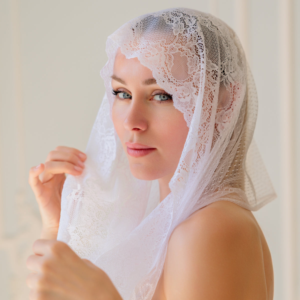 Woman wearing a Catholic Infinity Veil against a plain background