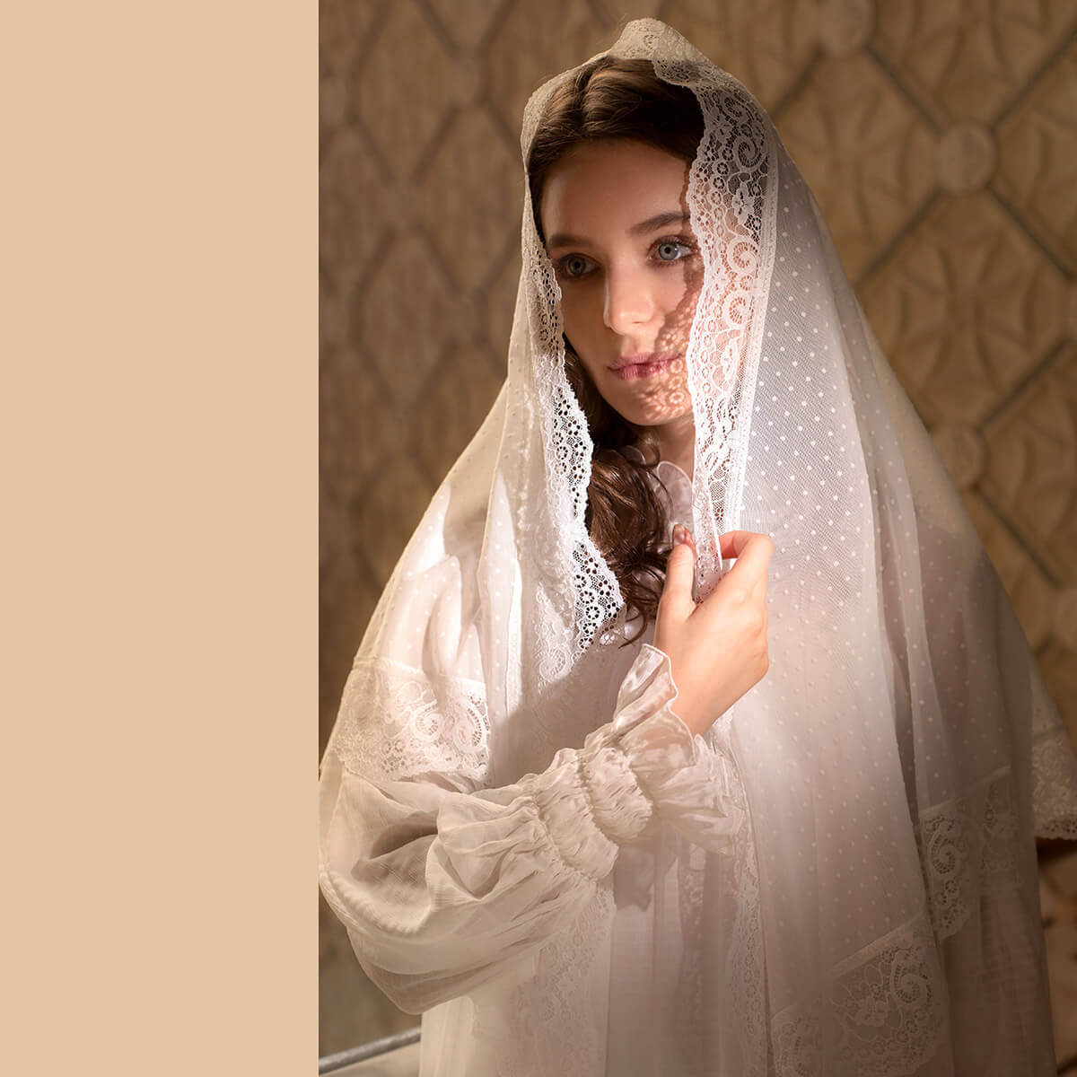 Woman wearing a Catholic Church Mantilla against a beige wall.