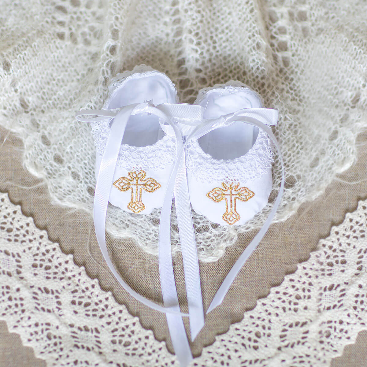  Christening Booties white ribbons on a lace background