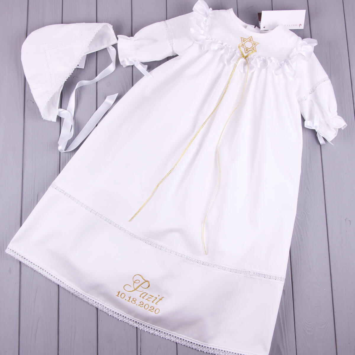 Christening Gown for Girls with bonnet on a wooden surface