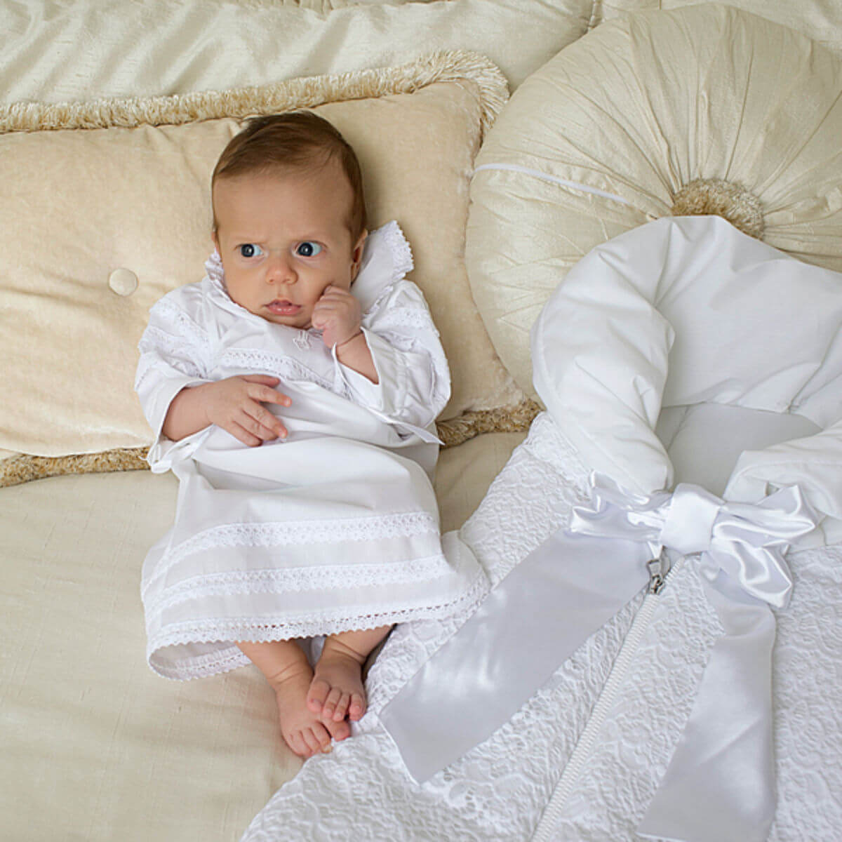 Baby wrapped in a Baptism Gown for Boy on a soft beige surface