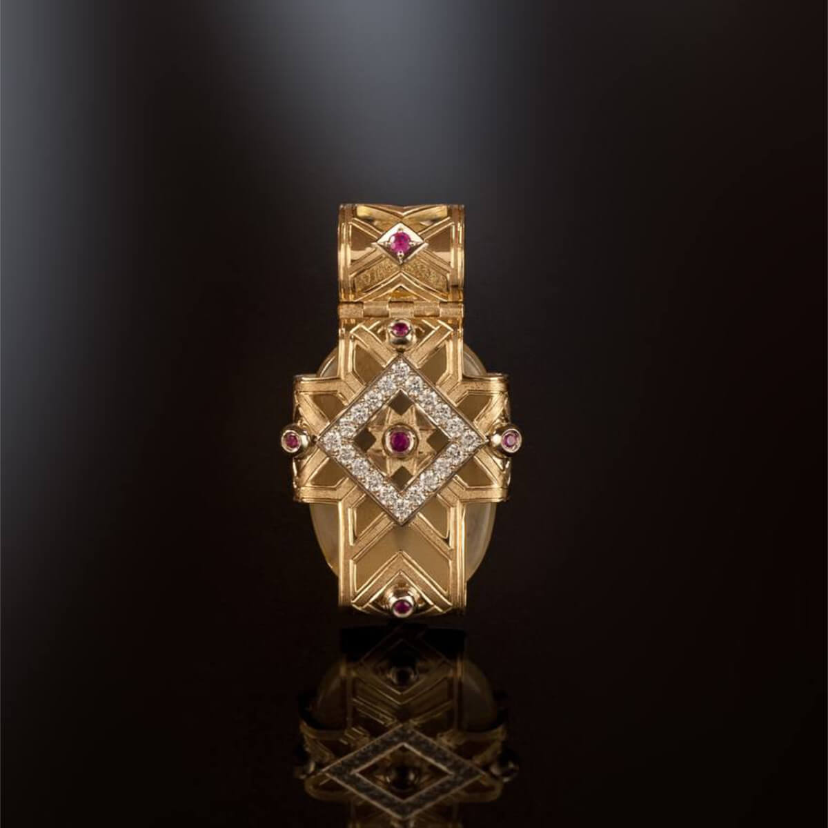 Gold pendant with gemstones on a black background