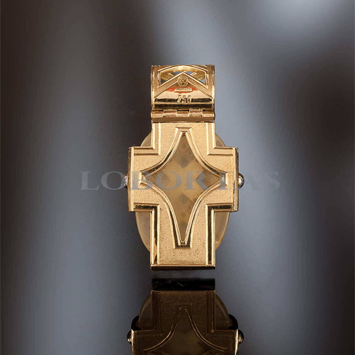 Gold cross pendant on a reflective surface with a dark background