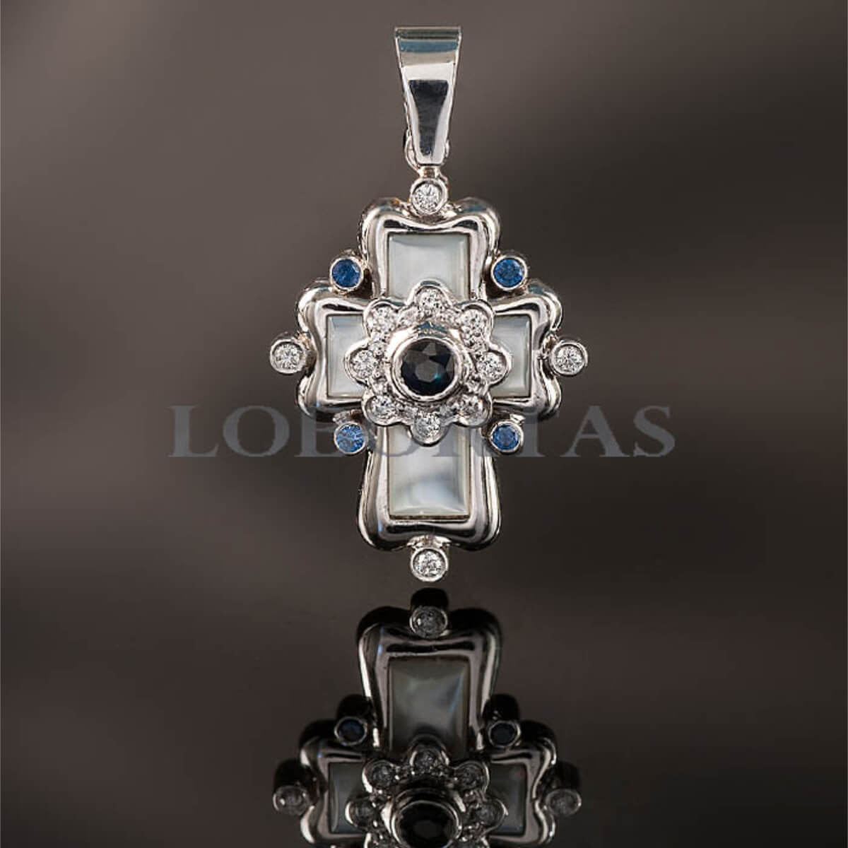Decorative silver pendant with gemstones on a dark background