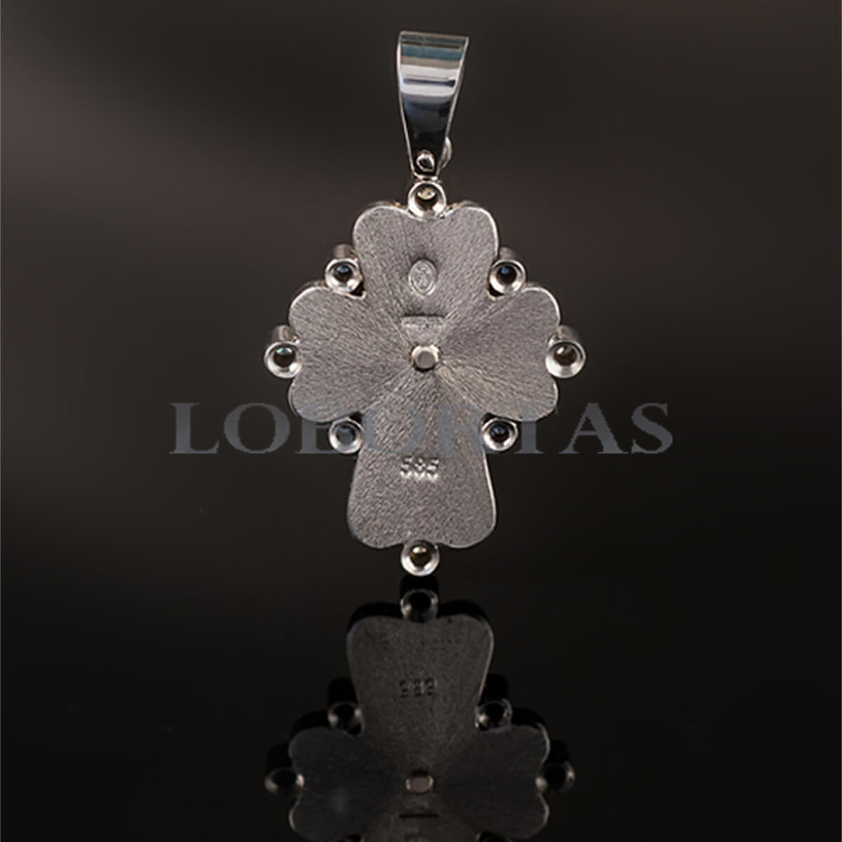 Silver cross pendant with floral design on a black background