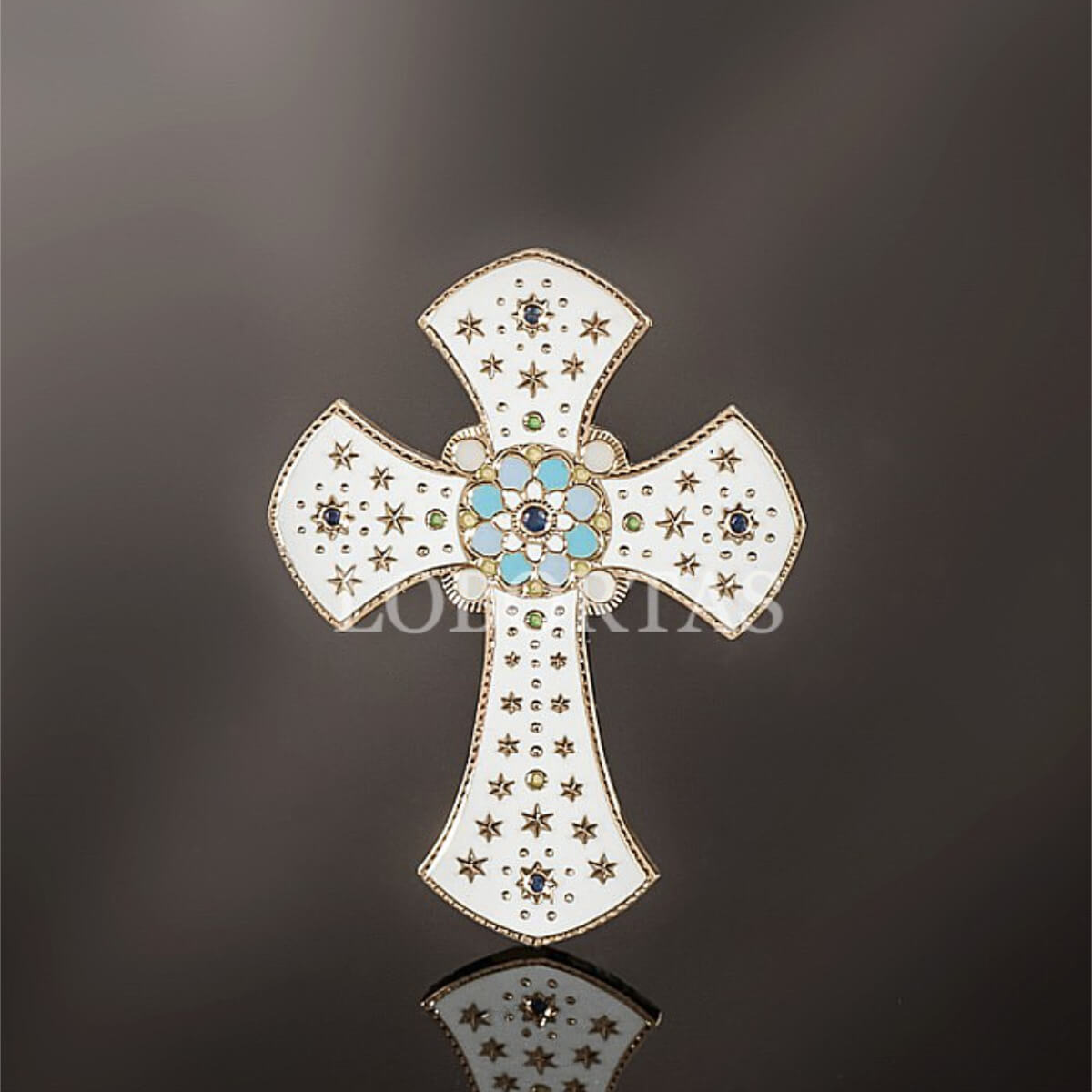 Decorative cross with gemstones on a reflective surface