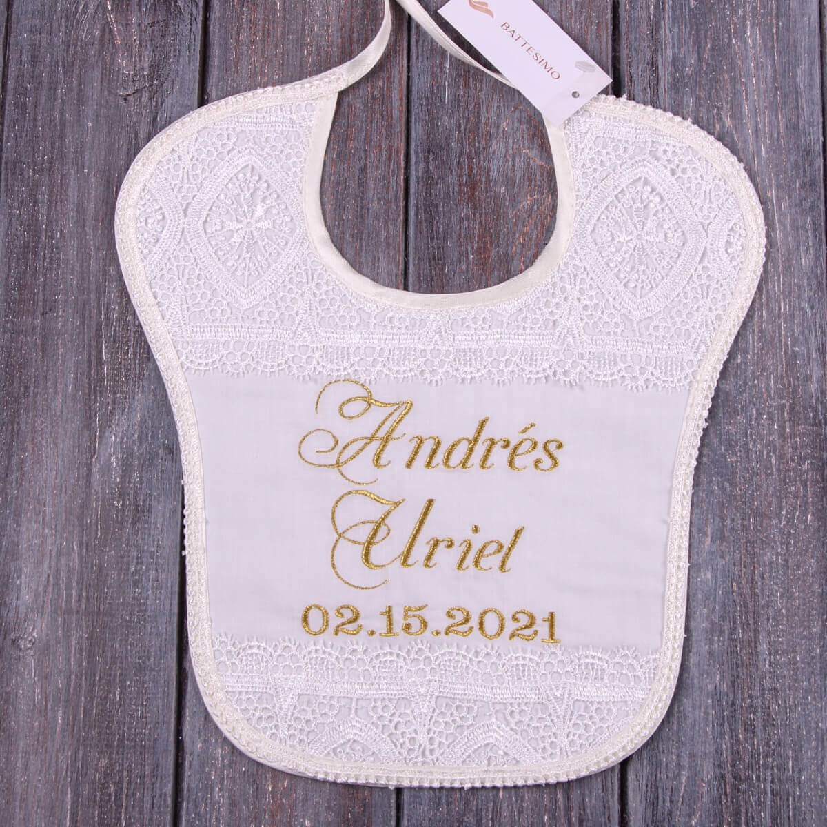 Baptism Bib with personalized name and date on a wooden surface