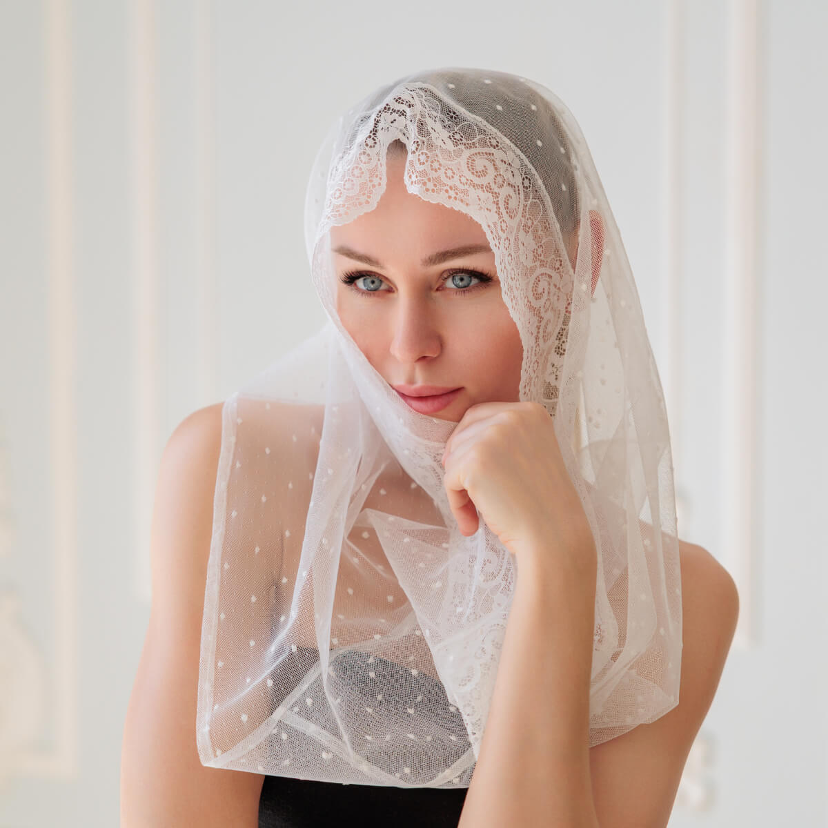 Woman wearing a Catholic Infinity Veil against a light background
