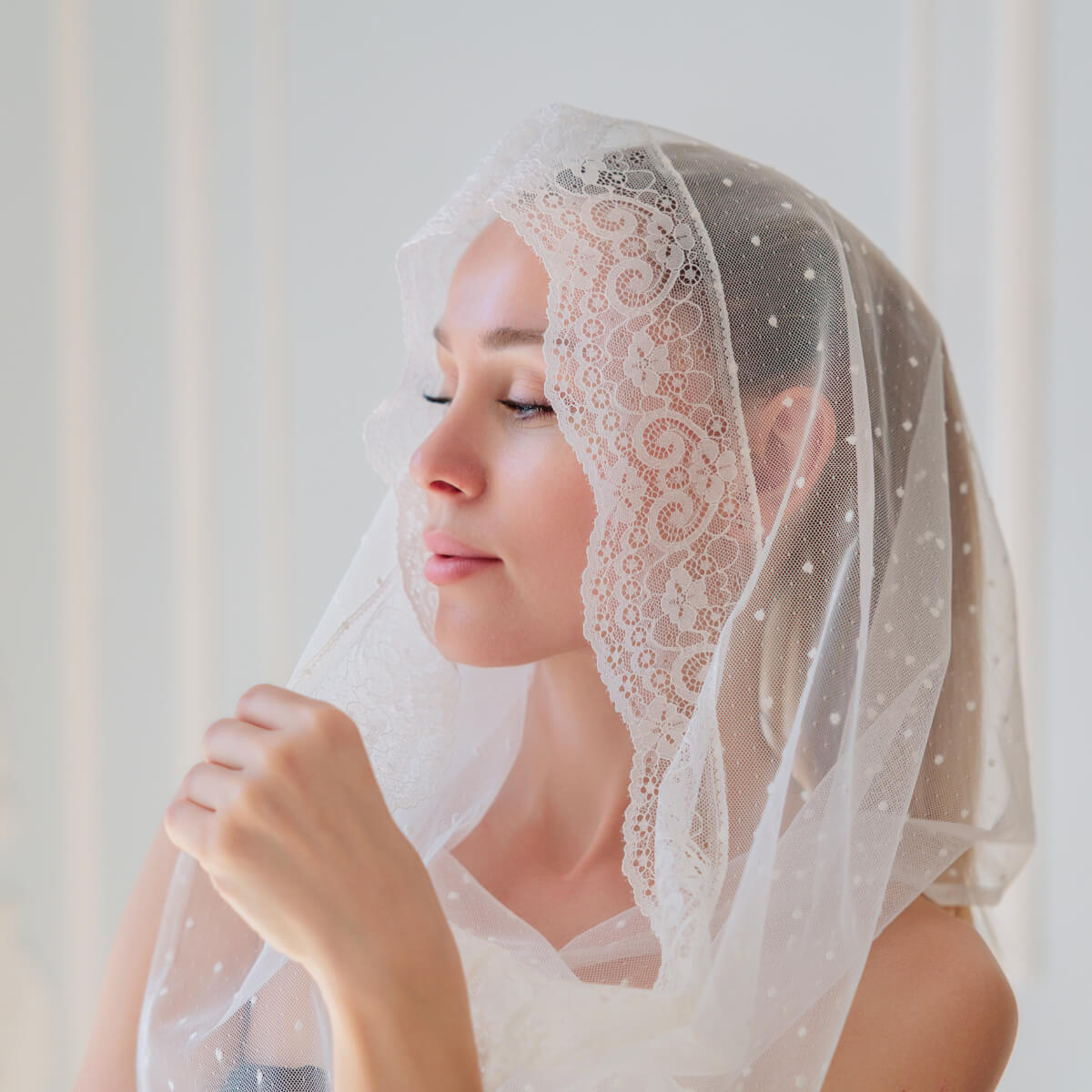 Woman wearing a Catholic Infinity Veil against a plain background