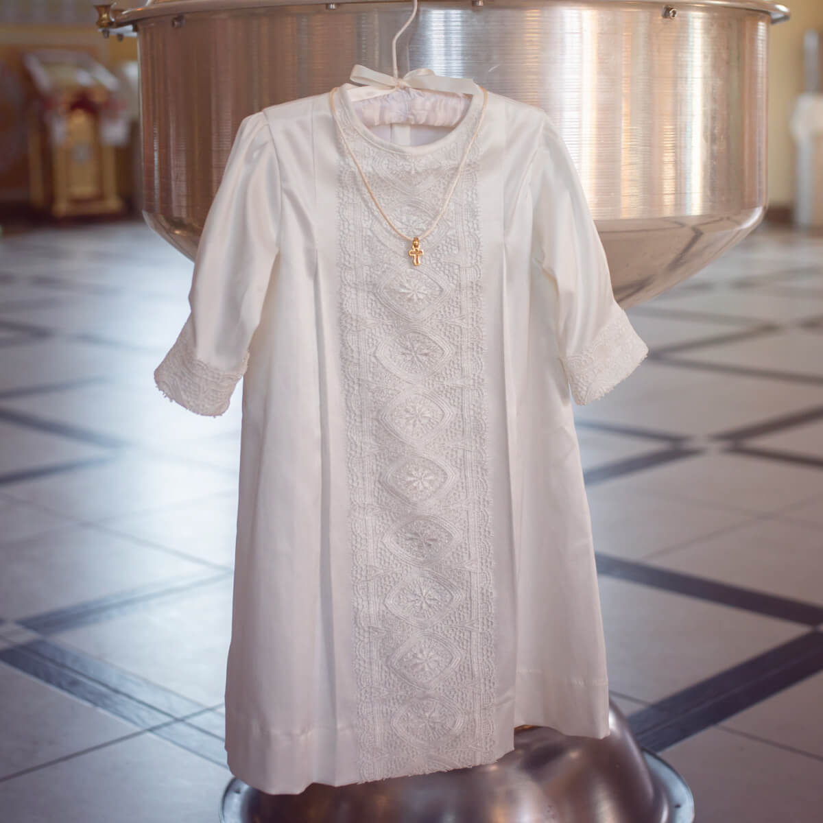  Baptism Gown for Boy on a hanger with a blurred background