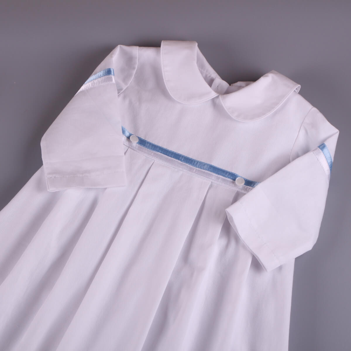Christening Outfit with blue trim on a gray background