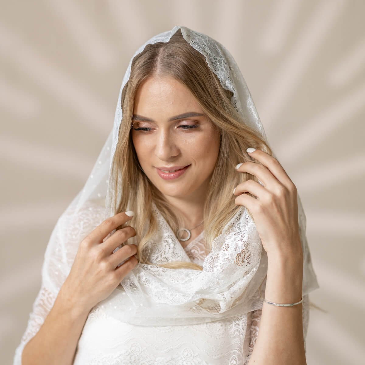 Woman wearing a Catholic Infinity Veil  against a beige background