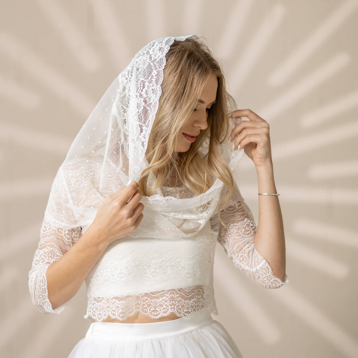 Woman wearing a Catholic Infinity Veil  against a beige background