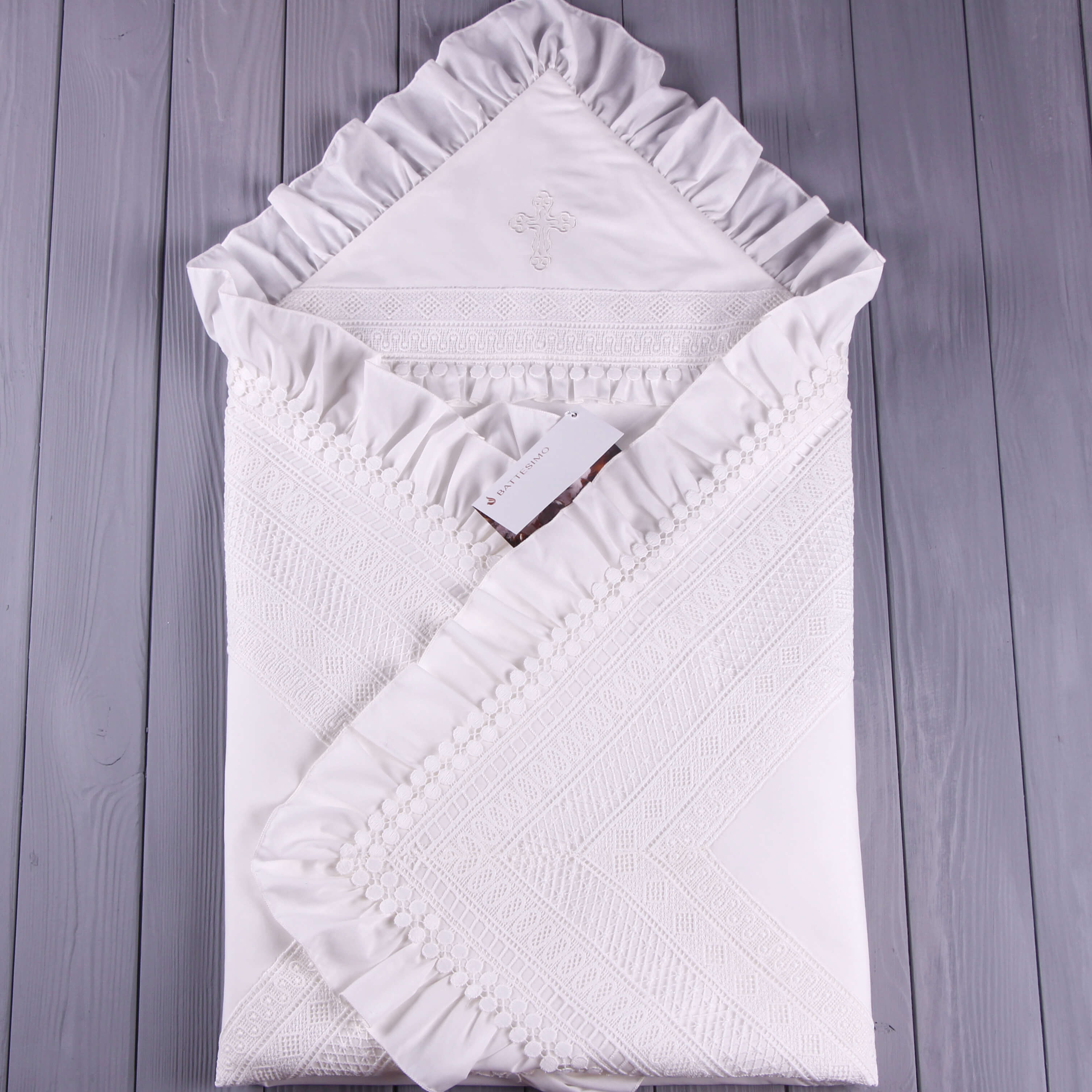White textured christening blanket on a wooden surface