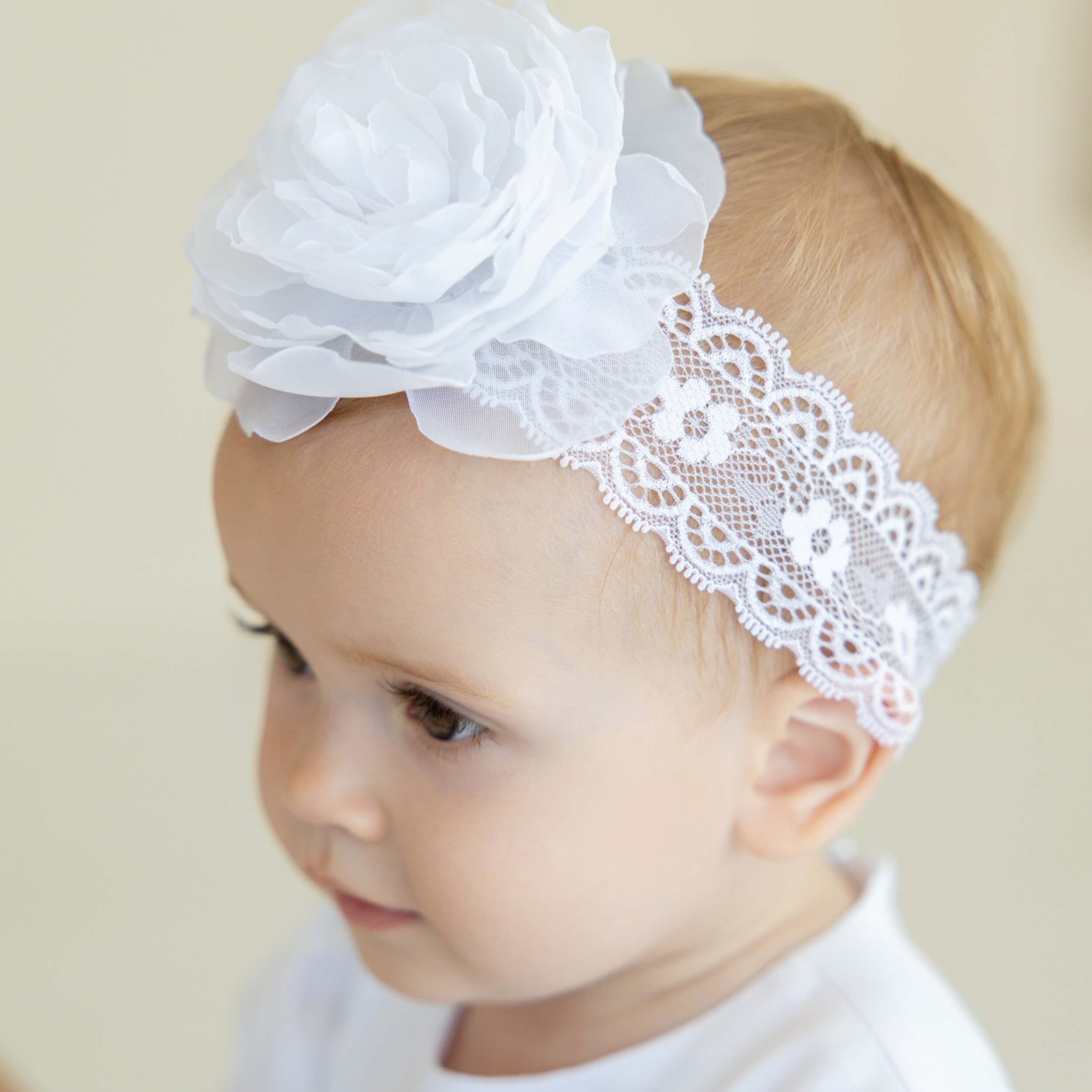 Baby headband with a large flower on a plain background