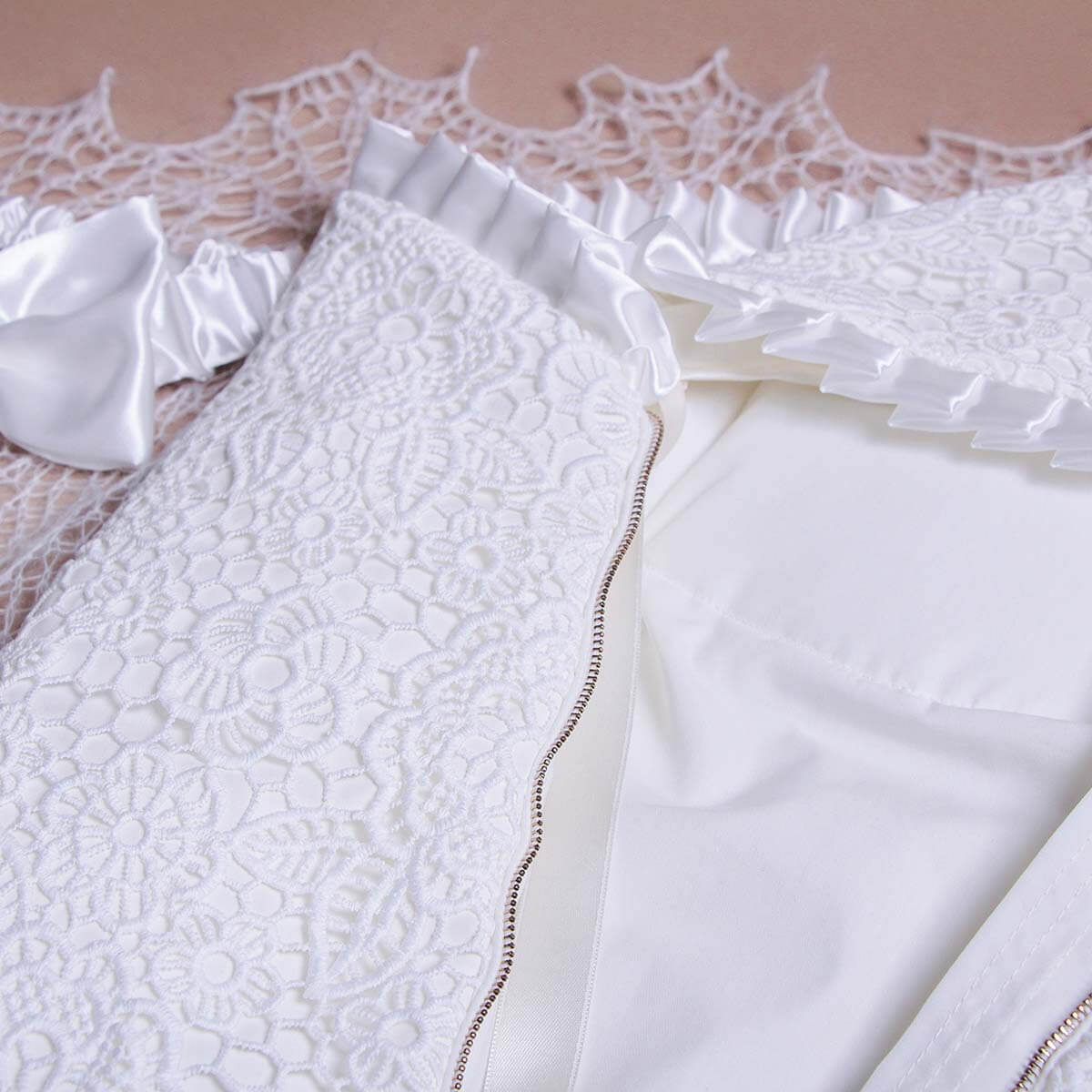 Close-up of a Sleeping sack with hat for summer  with intricate detailing on a beige background