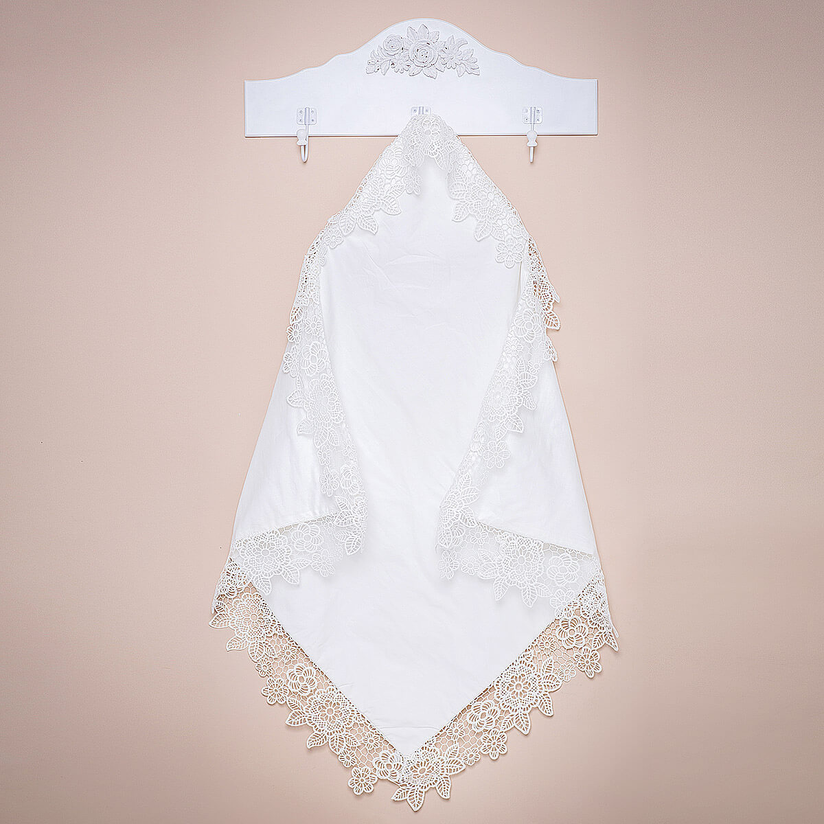 White lace christening blanket on a beige background
