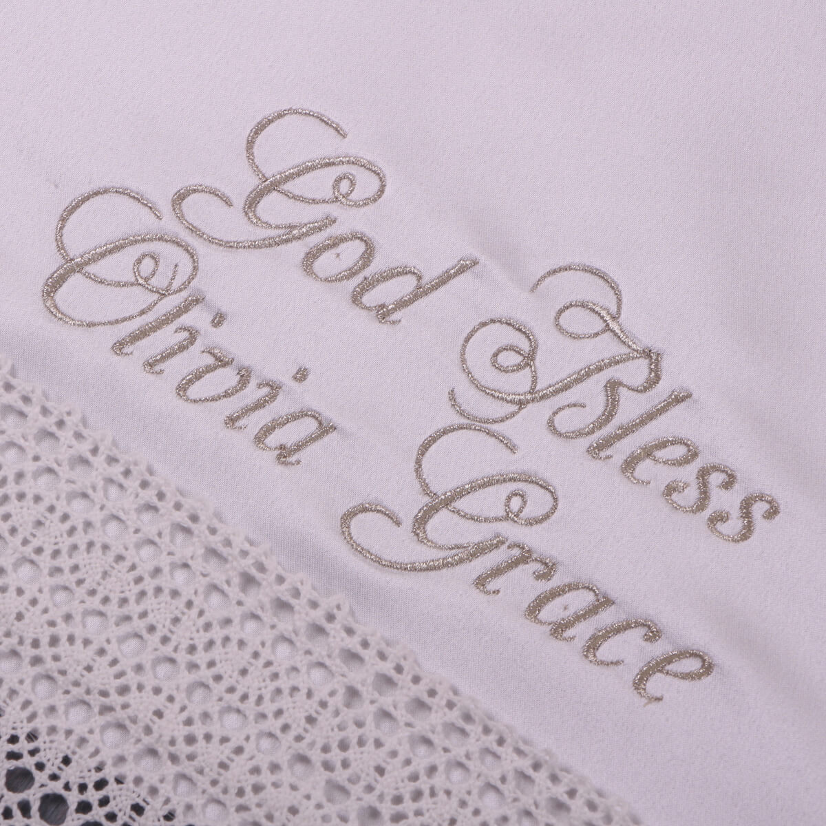 Embroidered text 'God Bless Olivia Grace' on a textured fabric background