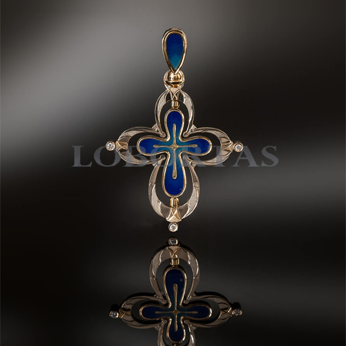 Handmade gold cross pendant with blue and gold elements on a dark background