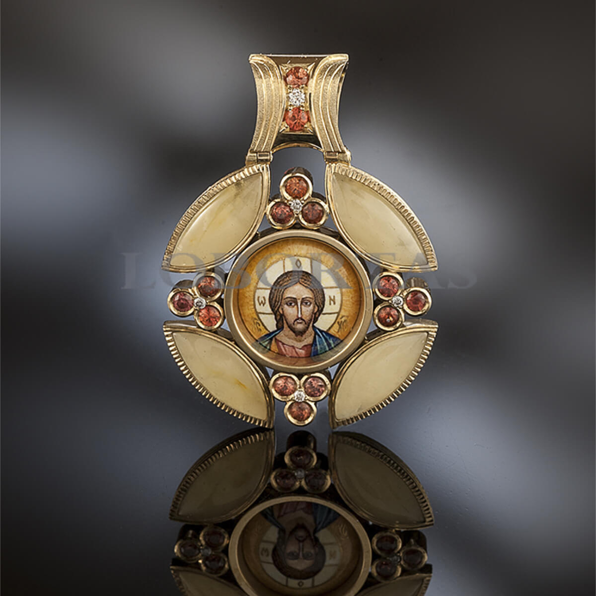 Decorative pendant with religious icon and gemstones on a dark background