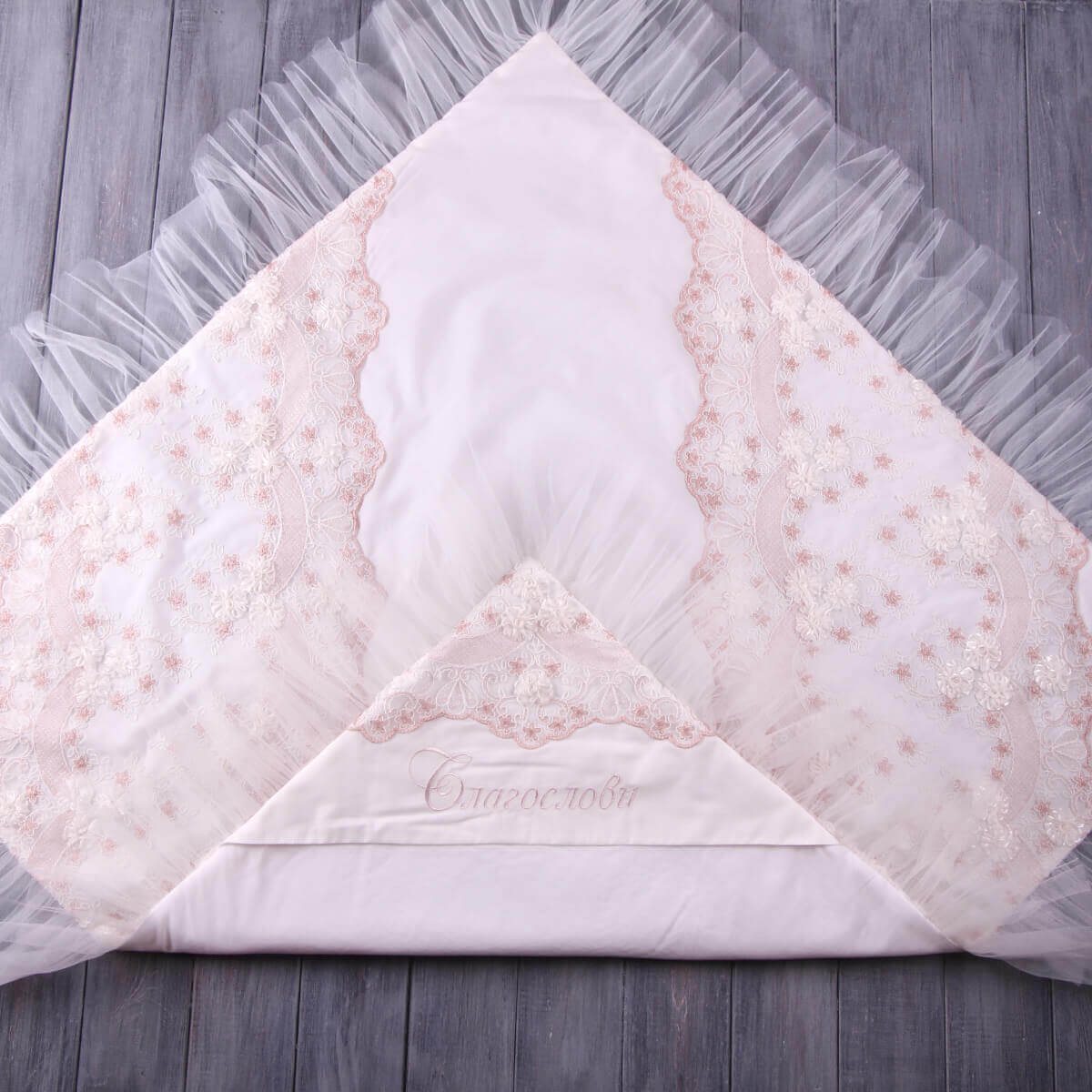 Baptism Blanket with floral pattern on a wooden surface