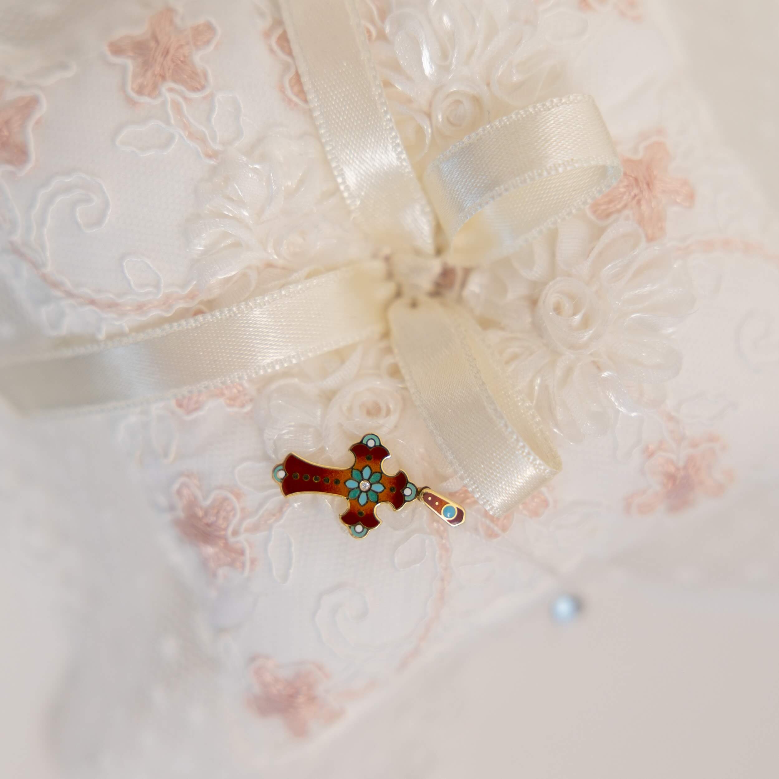 Close-up of a Baptism Ceremony Pillow on a white embroidered fabric background