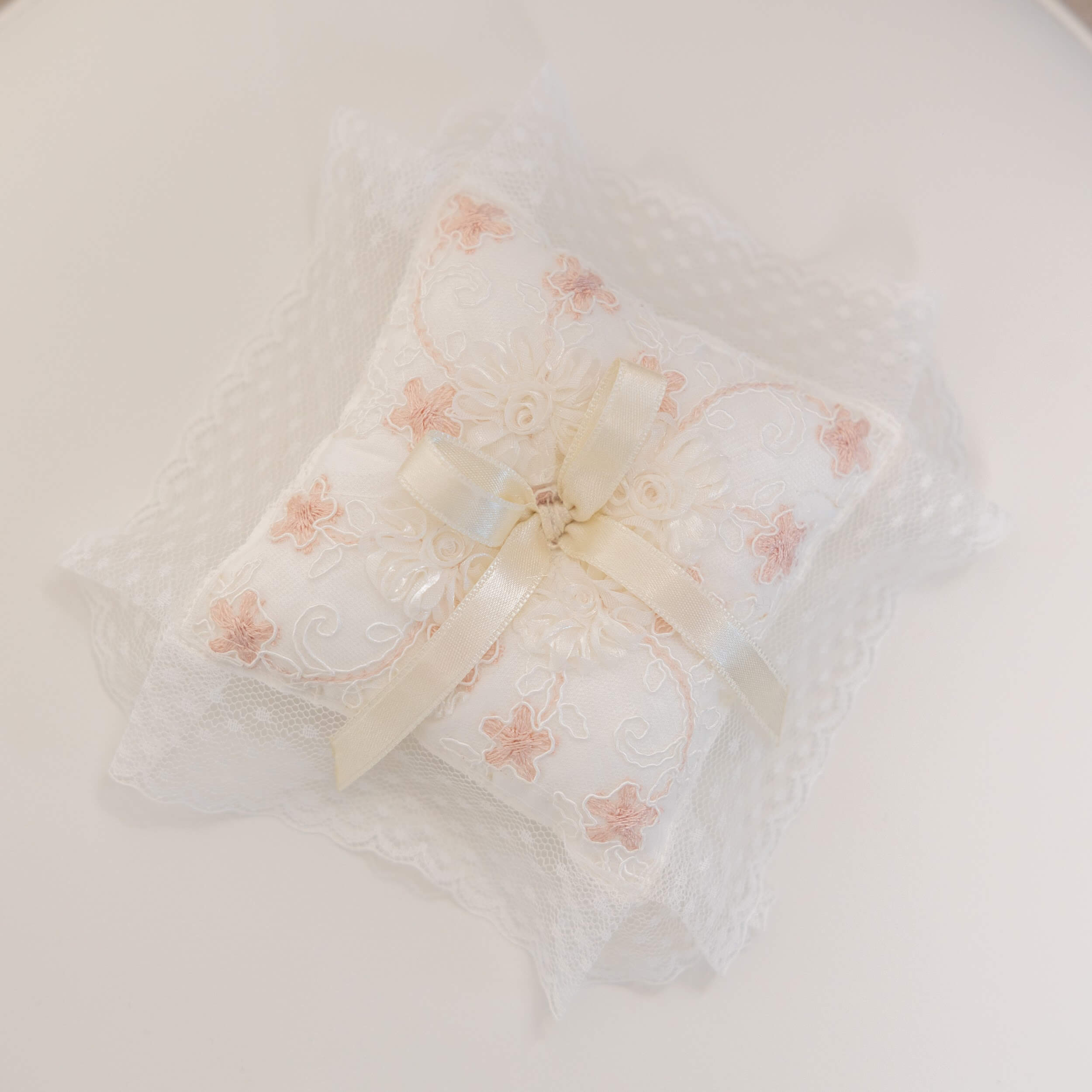 Baptism Ceremony Pillow with pink floral patterns and a bow on a white background