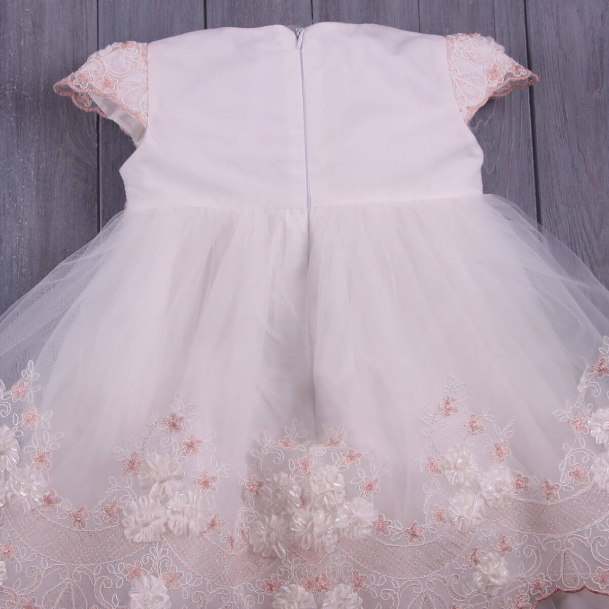 Baptism Dress with Floral Lace on a wooden background