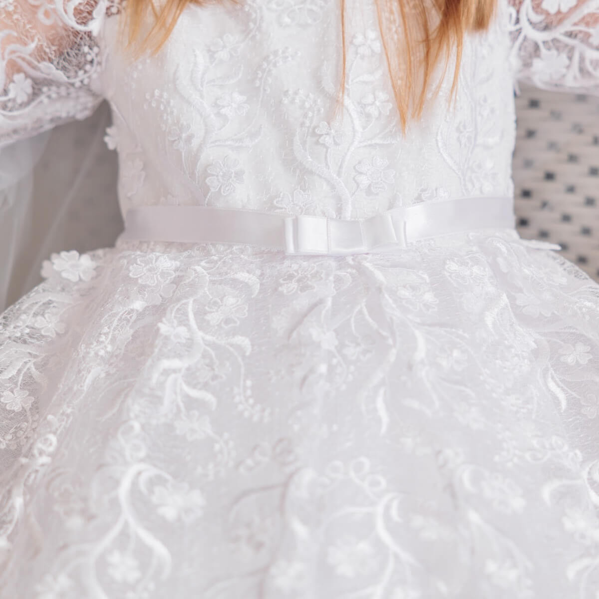 Close-up of a First Communion Dress with Veil with a bow detail.