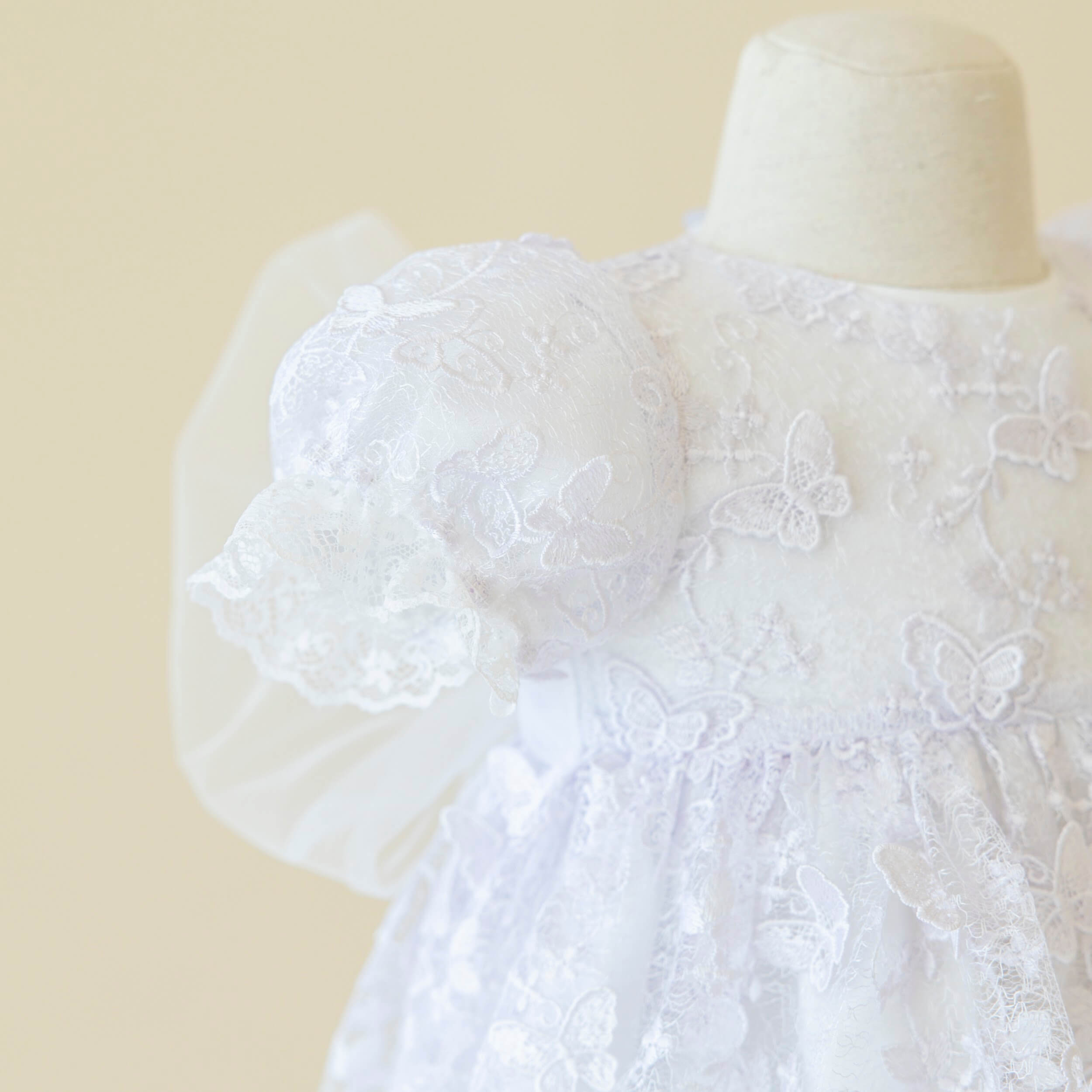 Baptism Dress Set  with butterfly details on a mannequin against a beige background