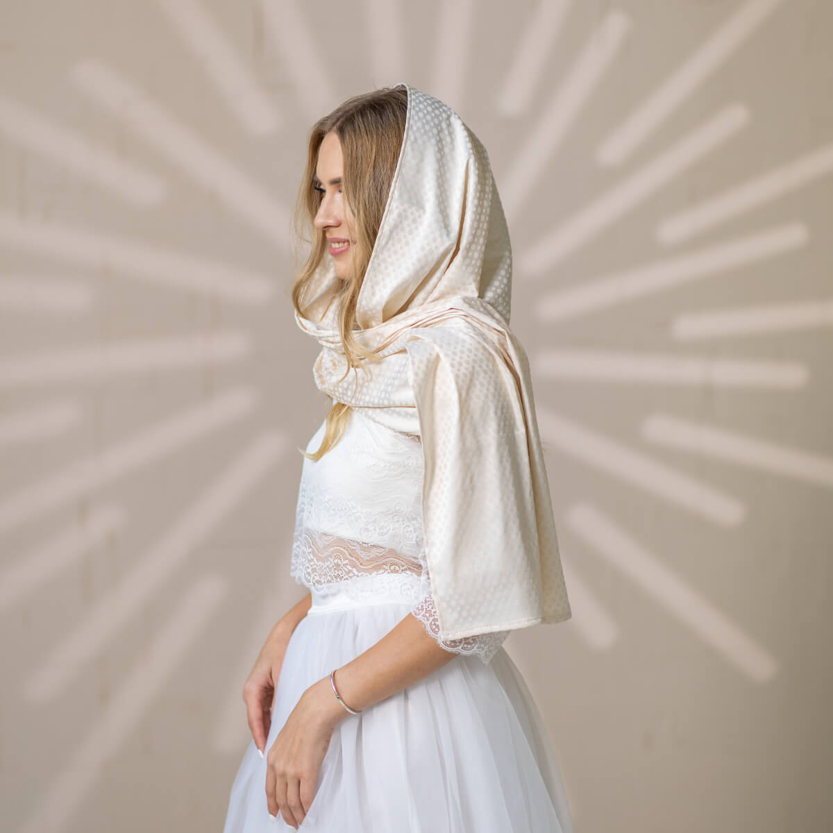 Woman wearing a white Silk Chapel Veil against a beige background