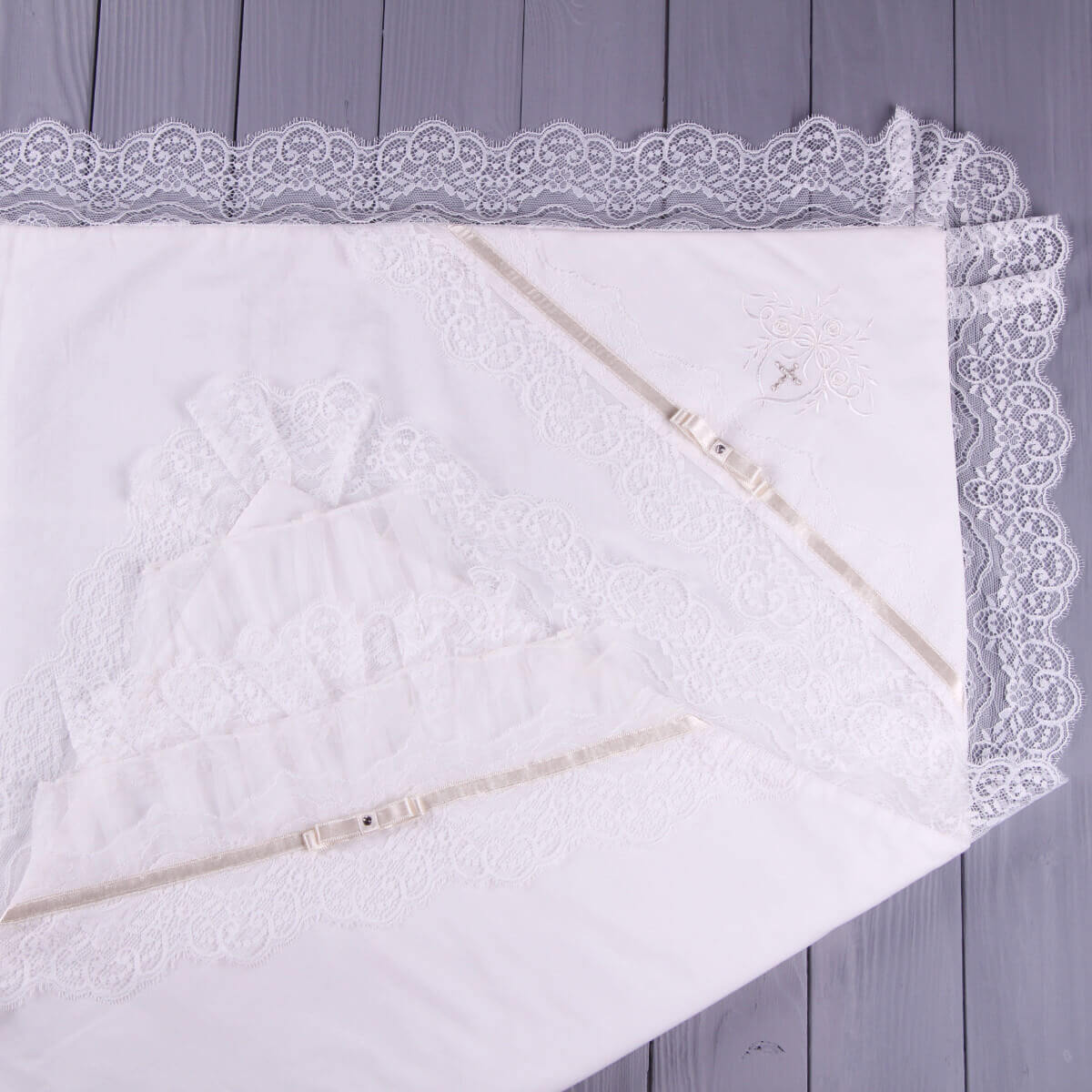 White christening blanket on a gray wooden surface