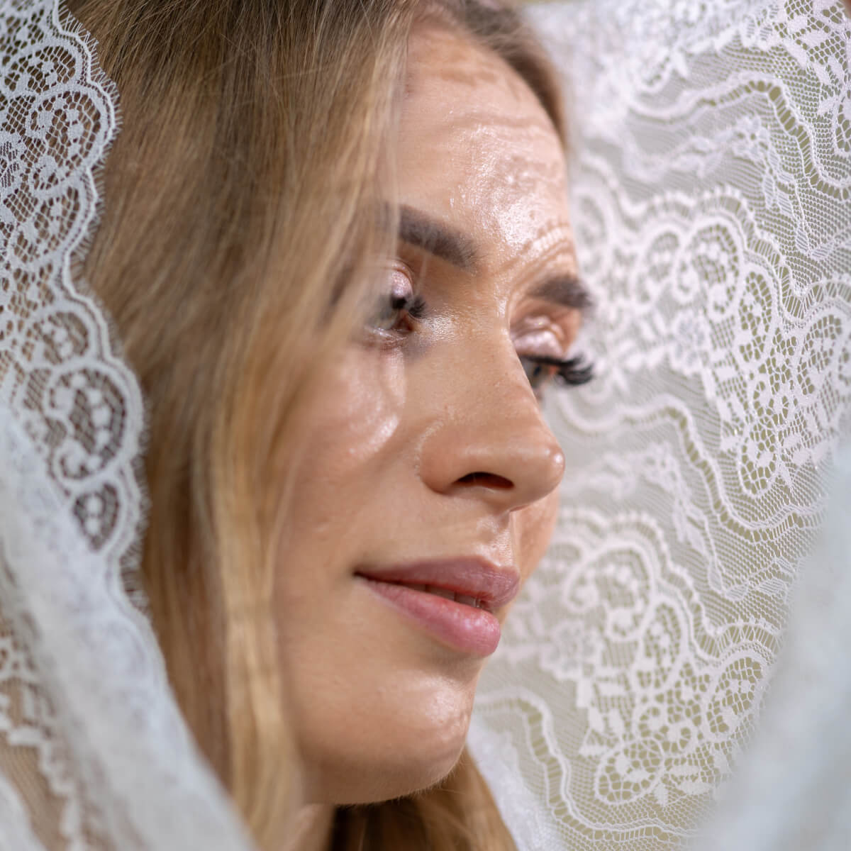 Close-up of a woman's face with Catholic Infinity Veil  in the background