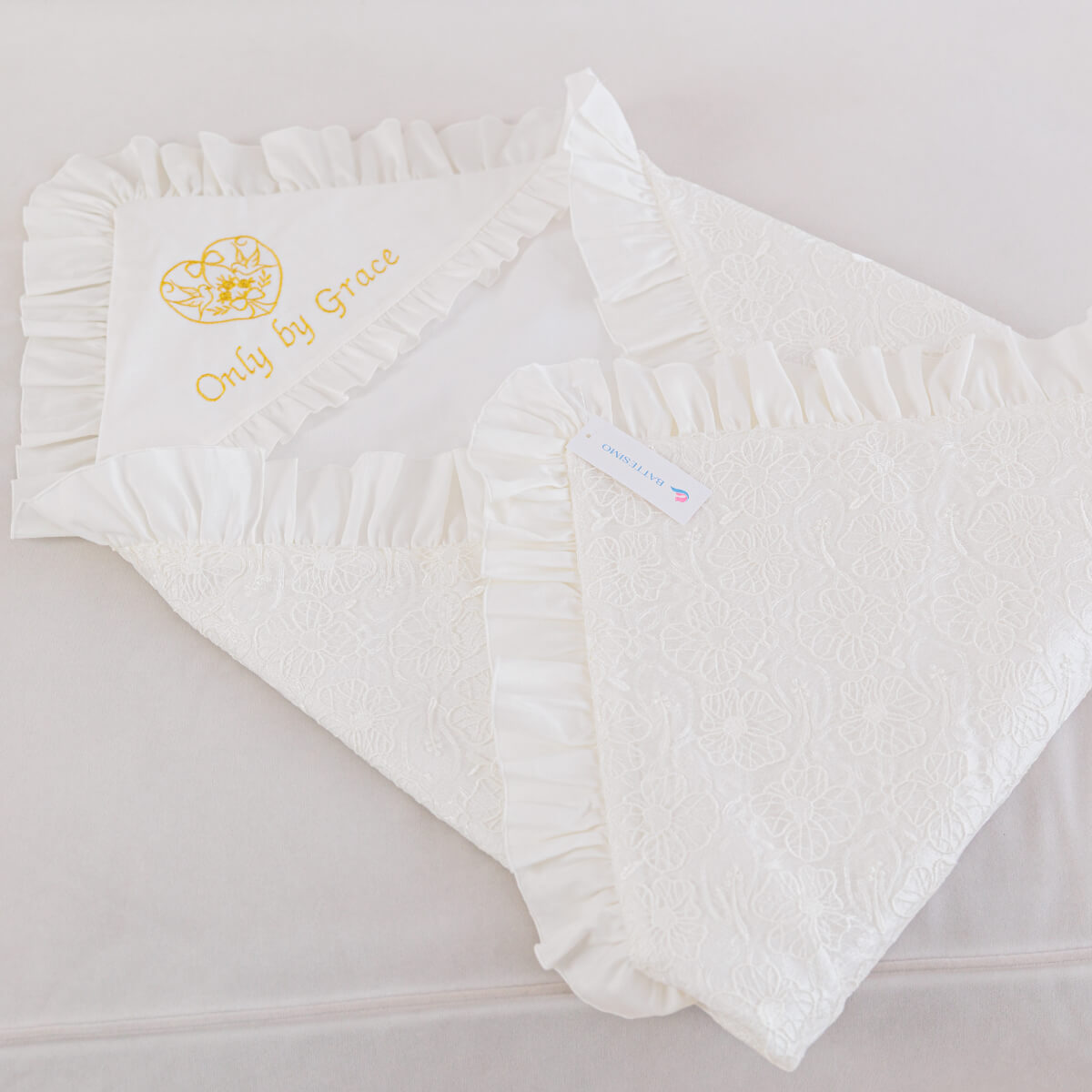 White baby baptism blanket with ruffled edges and 'Only by Grace' branding on a light gray background