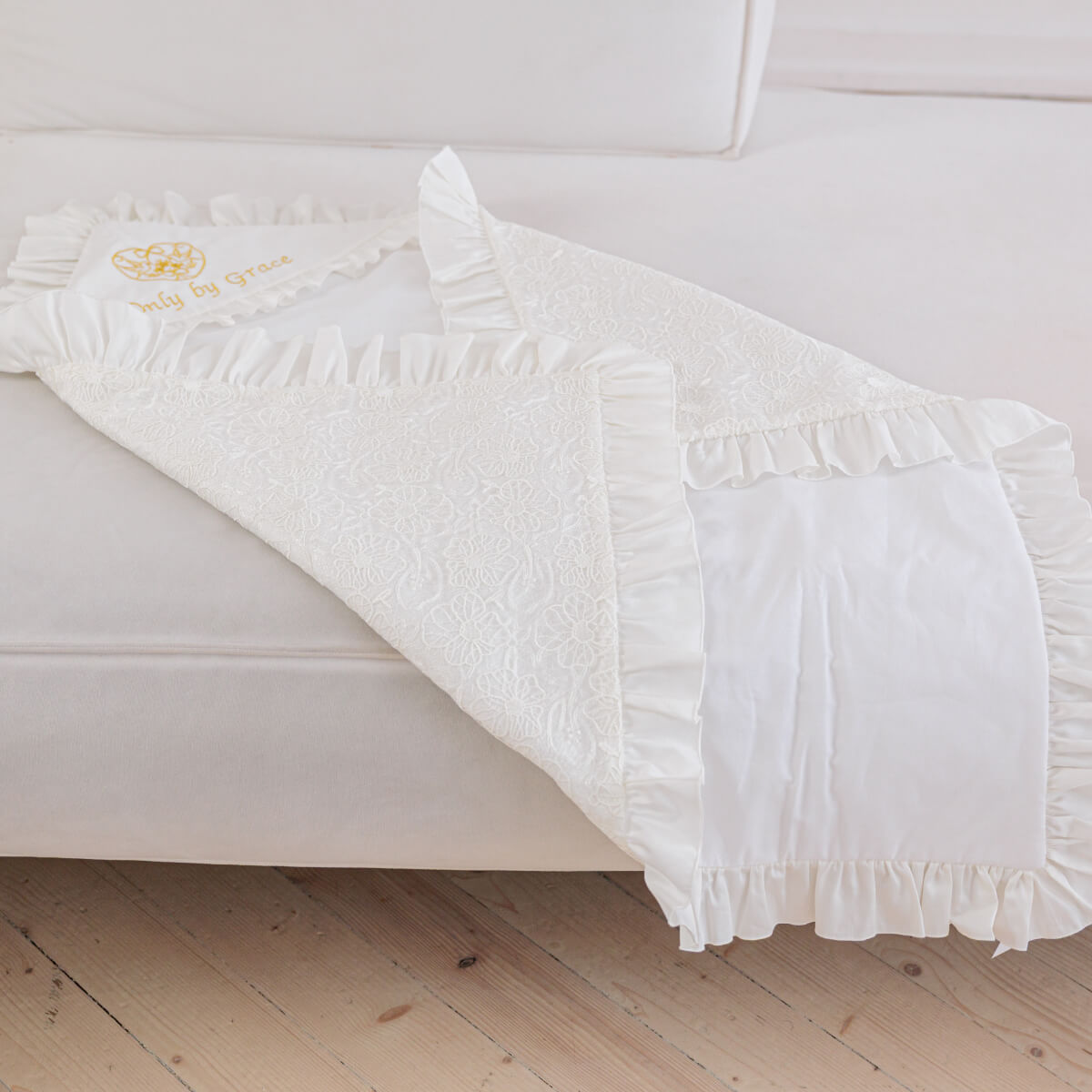 White baptism blanket with ruffles on a white crib